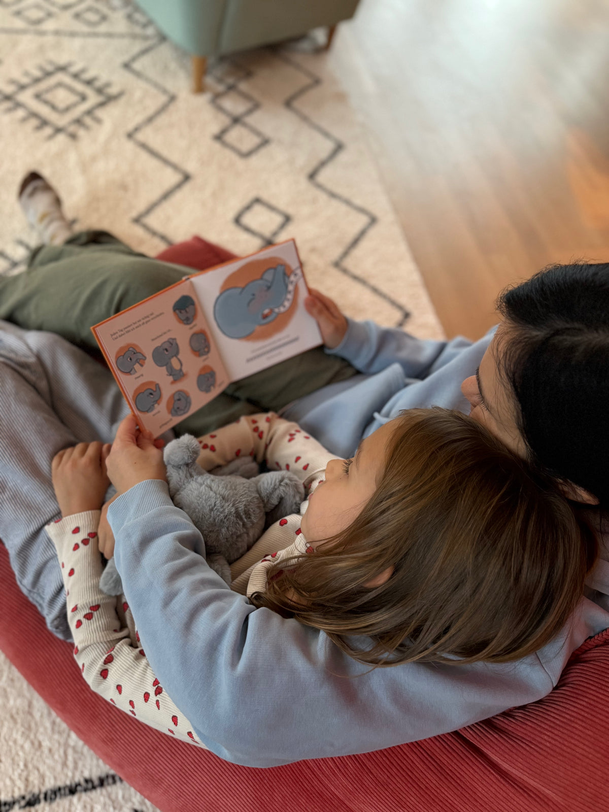 Familie liest gemeinsam auf dem Sofa